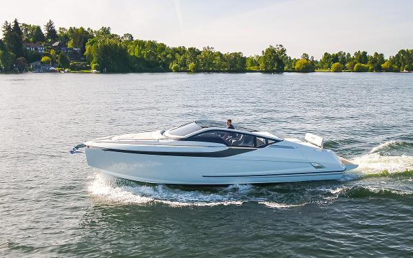 Slide: The Image of 2022 Fairline F//Line 33 yacht cruising on a serene lake with lush green surroundings. - 0