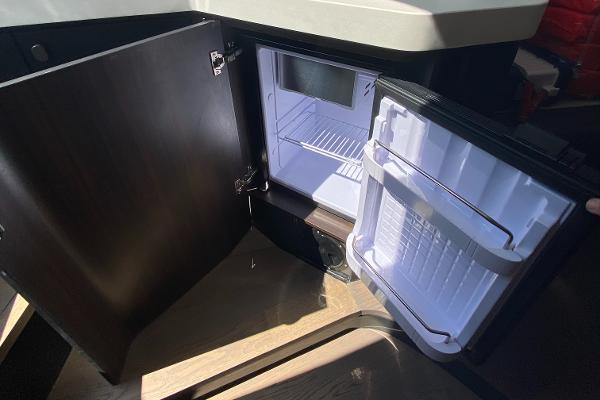 Slide: The Image of Open mini fridge inside 2022 Fairline F//Line 33 yacht, showcasing interior storage space. - 15