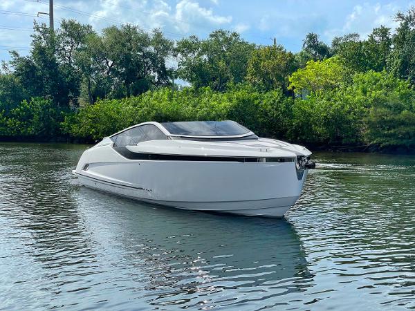 Slide: The Image of 2021 Fairline F Line 33 luxury yacht on calm water with lush greenery background. - 2
