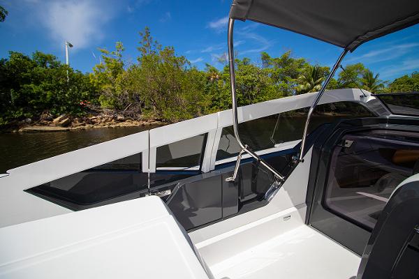 Slide: The Image of 2021 Fairline F Line 33 yacht cockpit with lush greenery in the background. - 46