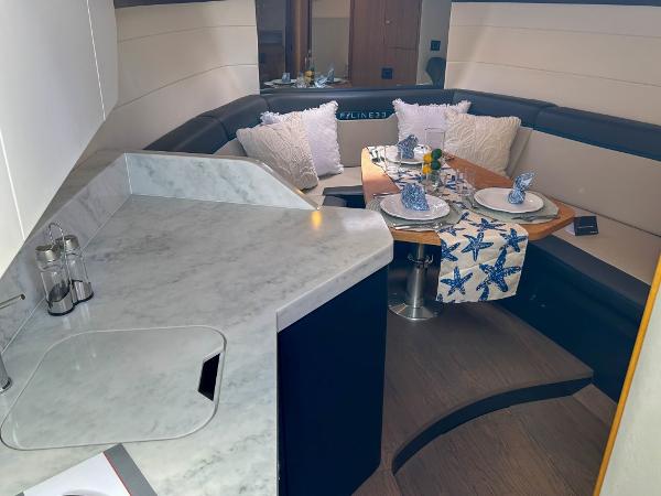 Slide: The Image of Luxurious interior of 2023 Fairline F//Line 33 Outboard yacht with dining area and kitchenette. - 11