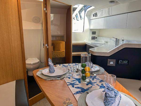 Slide: The Image of Luxurious interior of 2023 Fairline F//Line 33 Outboard with dining area, kitchenette, and bathroom. - 13