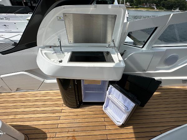 Slide: The Image of 2023 Fairline F//Line 33 Outboard yacht with open kitchenette and mini-fridge on deck. - 14