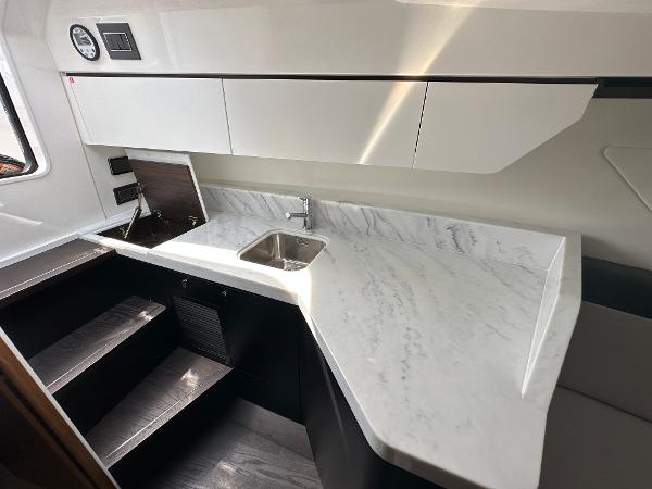 Slide: The Image of 2023 Fairline F//Line 33 Outboard yacht interior kitchen with marble countertop and sink. - 28