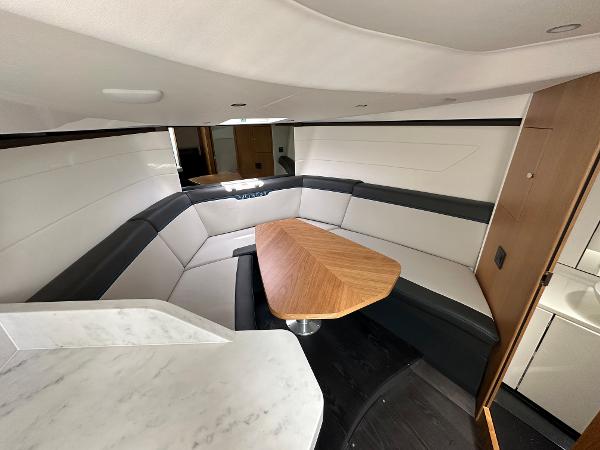 Slide: The Image of Interior of 2023 Fairline F//Line 33 Outboard with modern seating and wooden table. - 29