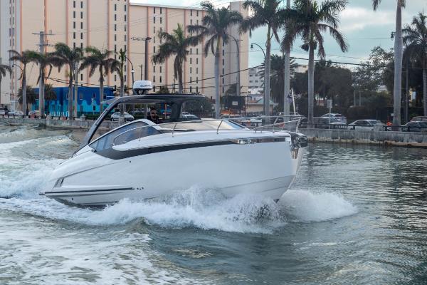 Slide: The Image of 2023 Fairline F//Line 33 Outboard cruising in a city canal with palm trees. - 7