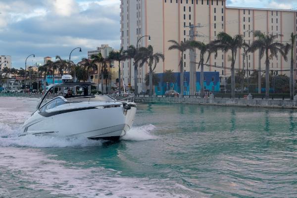Slide: The Image of 2023 Fairline F//Line 33 Outboard cruising in a city canal with palm trees and buildings. - 8