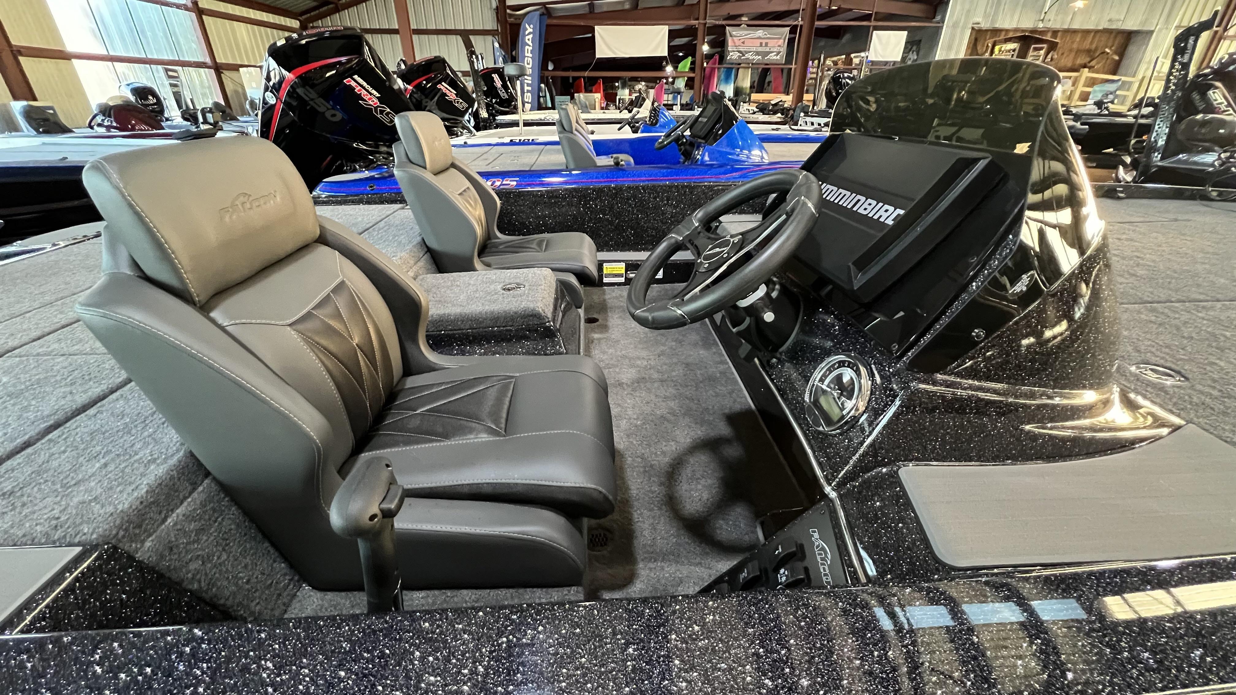 Slide: The Image of 2024 Falcon F205 boat interior with steering wheel and seats in showroom. - 14
