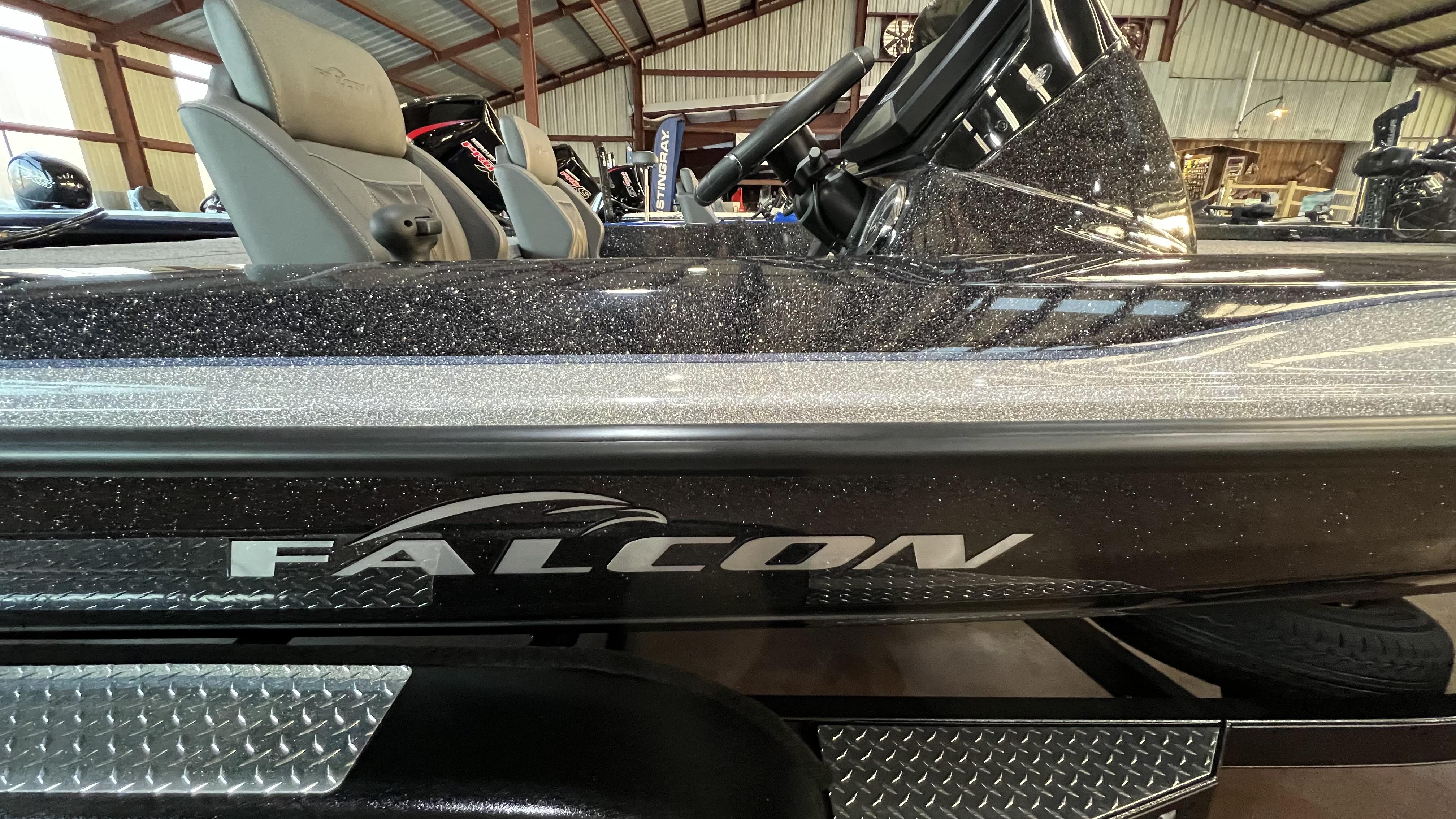 Slide: The Image of 2024 Falcon F205 boat interior with steering wheel and seats in a showroom. - 2