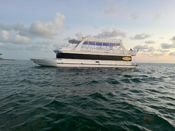 Slide: The Image of 2009 Fantasy Houseboat on open water at sunset. - 1
