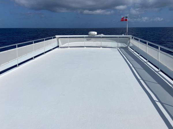 Slide: The Image of 2009 Fantasy Houseboat deck with ocean view and flag, clear sky background. - 29