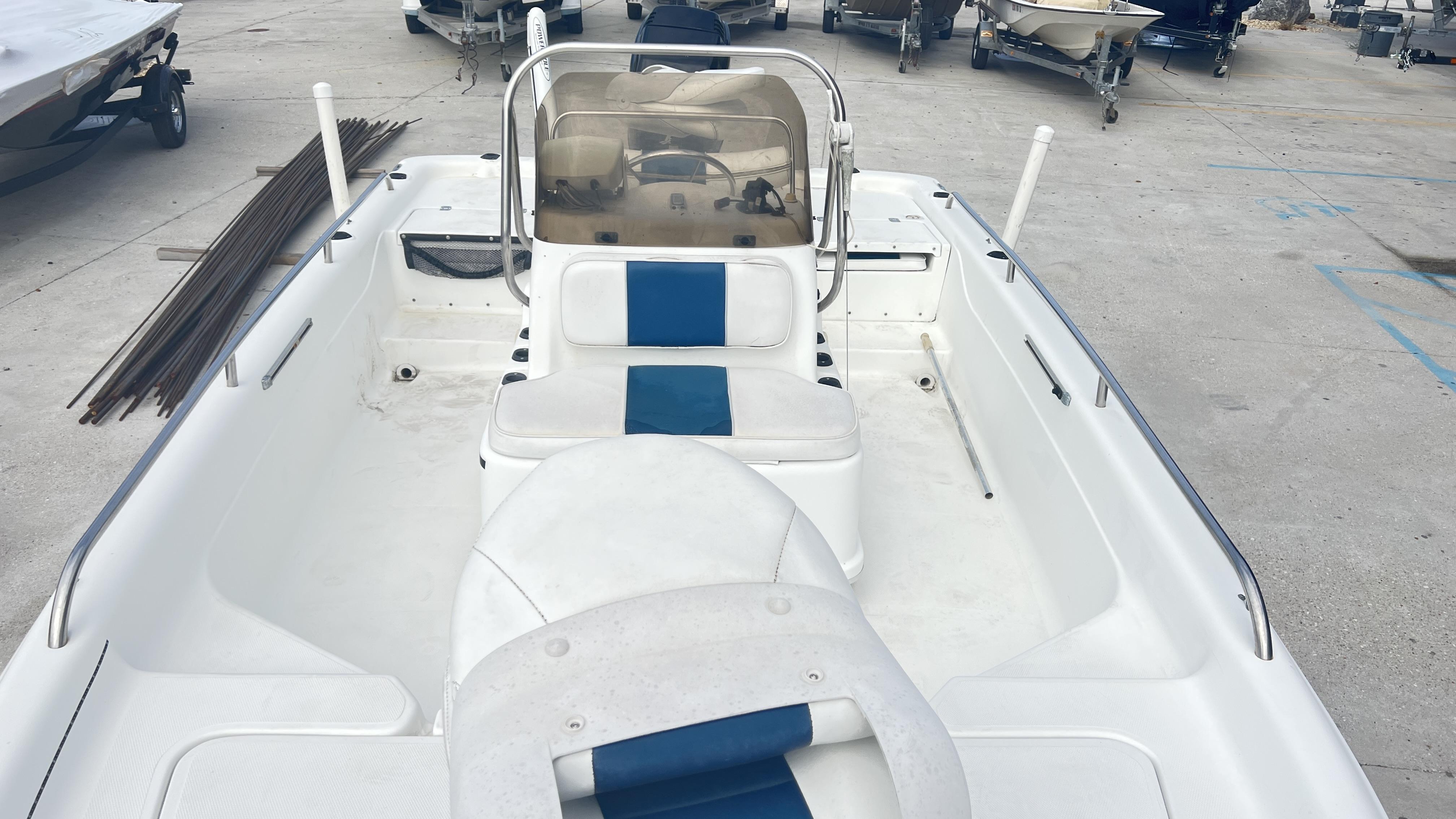 Slide: The Image of 2002 Fishmaster 1900 boat with blue and white seating, docked on concrete. - 3
