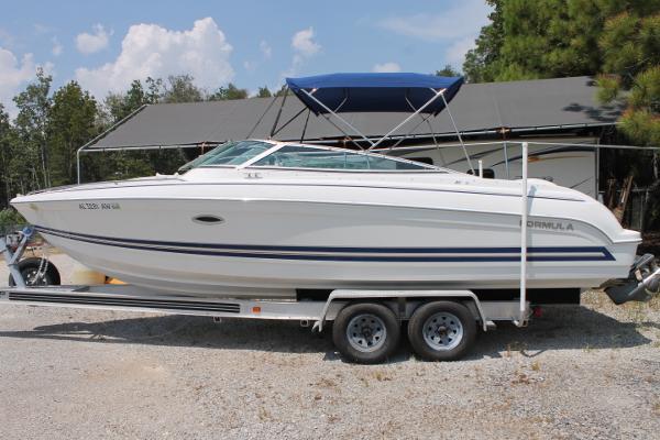 Slide: The Image of 2001 Formula 260 Sun Sport boat on trailer with blue canopy, parked outdoors. - 0