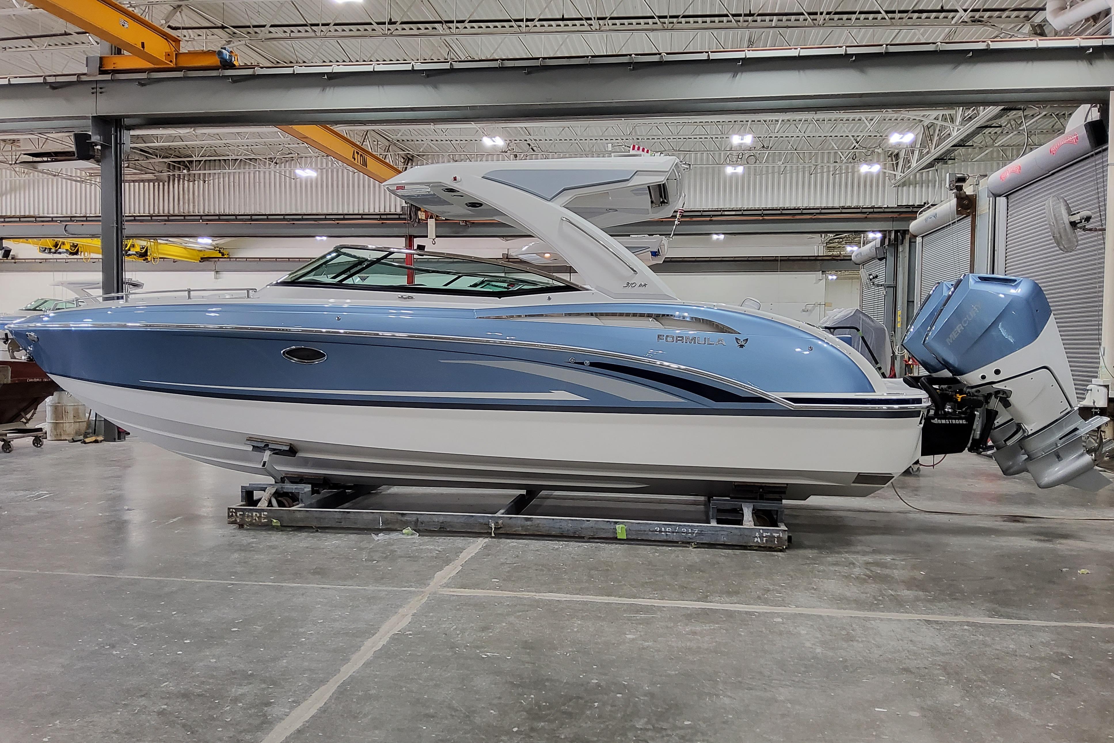 Slide: The Image of 2026 Formula 310 Bowrider OB in a warehouse, showcasing sleek design and outboard motor. - 2