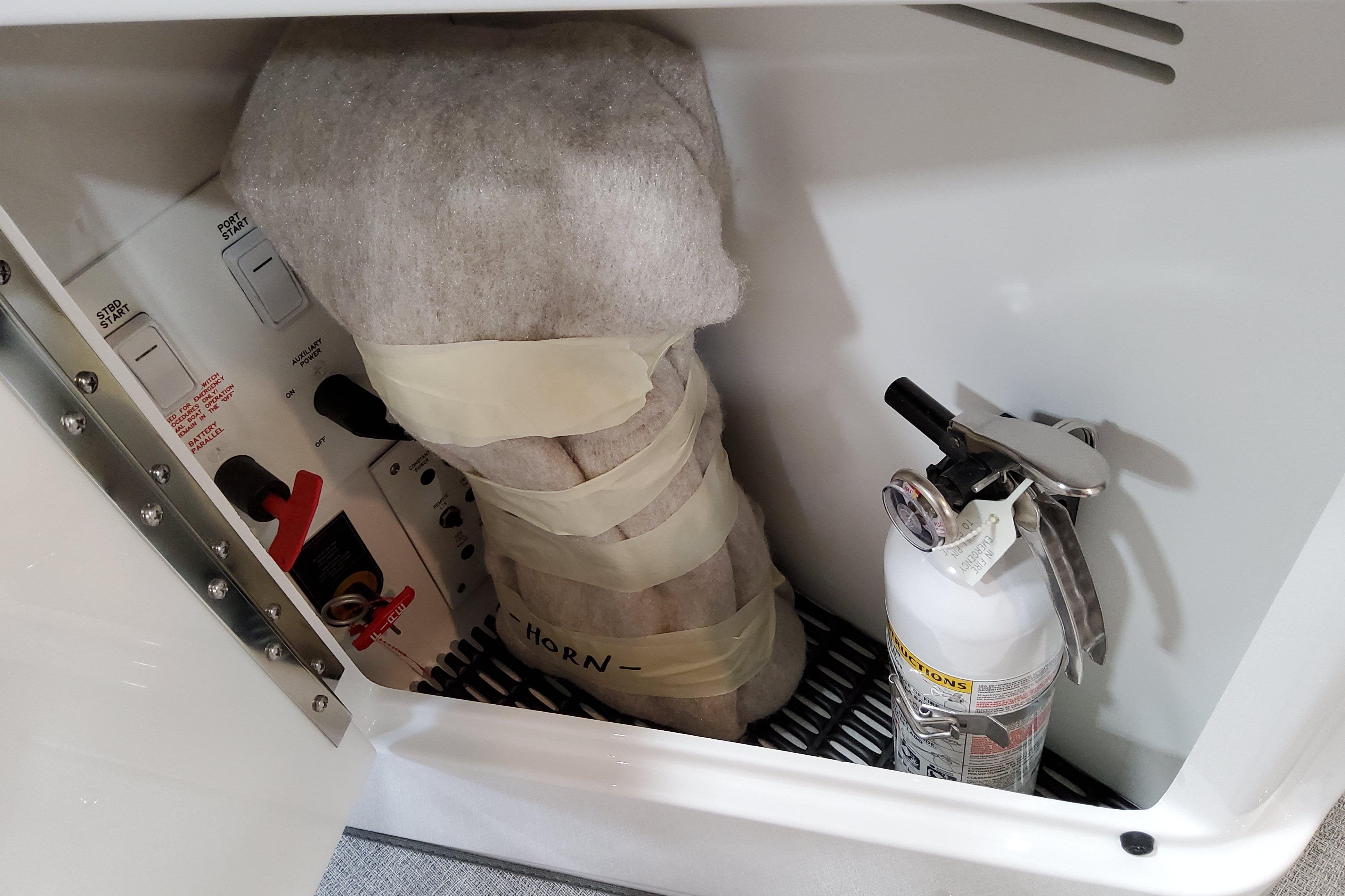 Slide: The Image of Storage compartment in 2026 Formula 310 Bowrider OB with fire extinguisher and wrapped equipment. - 26