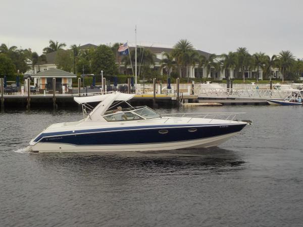 Slide: The Image of 2006 Formula 330 SS boat cruising on a calm waterfront near a marina. - 2