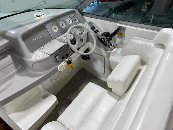 Slide: The Image of 1999 Formula 330 SS Sun Sport boat cockpit with white leather seats and control panel. - 9
