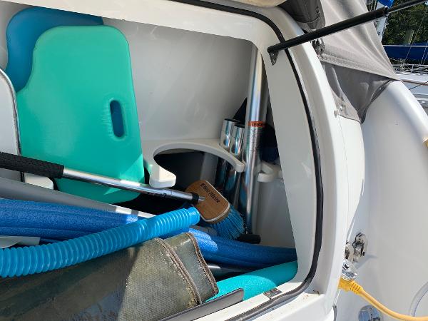 Slide: The Image of Storage compartment of a 2005 Formula 34 PC boat with cleaning supplies and pool noodles. - 35