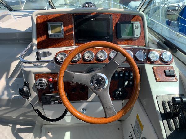 Slide: The Image of 2005 Formula 34 PC boat helm with wood-trimmed steering wheel and navigation instruments. - 49