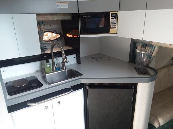 Slide: The Image of 1990 Formula 36 PC boat kitchen with sink, stove, microwave, and refrigerator. - 13