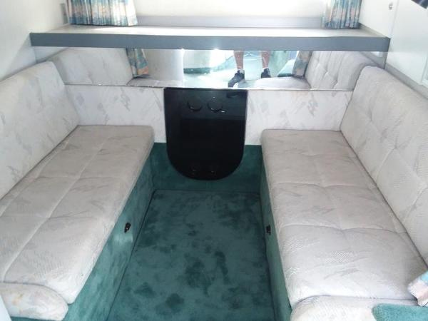 Slide: The Image of 1990 Formula 36 PC boat interior with cushioned seating and green carpet. - 14