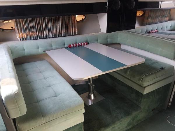 Slide: The Image of 1990 Formula 36 PC boat interior with cushioned seating and dining table. - 16