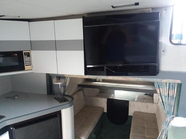 Slide: The Image of Interior of a 1990 Formula 36 PC boat with TV, kitchenette, and seating area. - 18