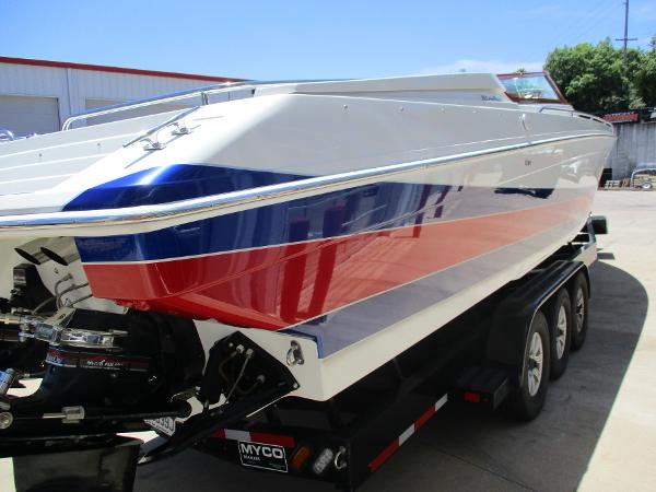 Slide: The Image of 1997 Formula 382 FASTech boat with red, white, and blue stripes on a trailer. - 4