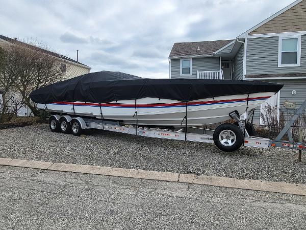 Slide: The Image of 2000 Formula 382 FASTech boat covered on a trailer in a residential driveway. - 13