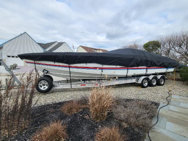 Slide: The Image of 2000 Formula 382 FASTech boat covered on a trailer in a residential driveway. - 14