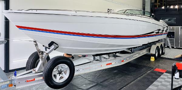 Slide: The Image of 2000 Formula 382 FASTech boat on trailer, white with red and blue stripes, in showroom. - 24