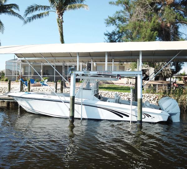 Slide: The Image of 2008 Fountain 34 CC boat docked under canopy with palm trees in background. - 0