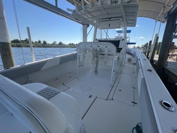 Slide: The Image of 2008 Fountain 34 CC boat interior with white seating and open deck, docked by the water. - 10