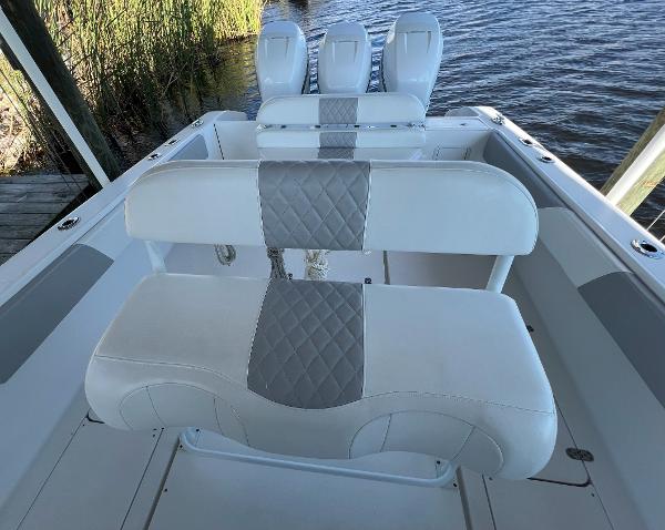 Slide: The Image of 2008 Fountain 34 CC boat interior with white and gray seating, docked by the water. - 11