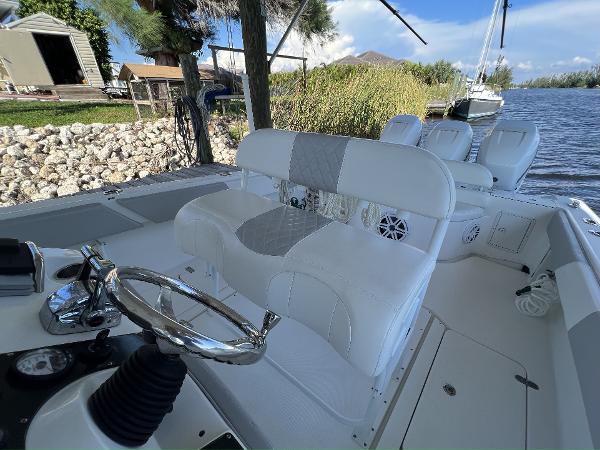 Slide: The Image of 2008 Fountain 34 CC boat interior with steering wheel and seating by the water. - 12
