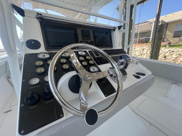 Slide: The Image of 2008 Fountain 34 CC boat dashboard with steering wheel and control panel. - 14