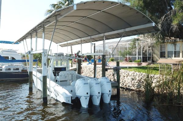 Slide: The Image of 2008 Fountain 34 CC boat docked under canopy with triple outboard engines. - 2