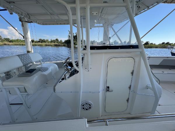 Slide: The Image of 2008 Fountain 34 CC boat interior with helm and seating, on a calm waterway. - 20