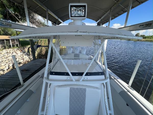 Slide: The Image of 2008 Fountain 34 CC boat docked by a serene lake under a canopy. - 22