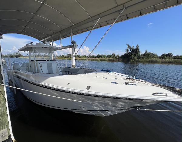 Slide: The Image of 2008 Fountain 34 CC boat docked under canopy on a sunny day. - 4