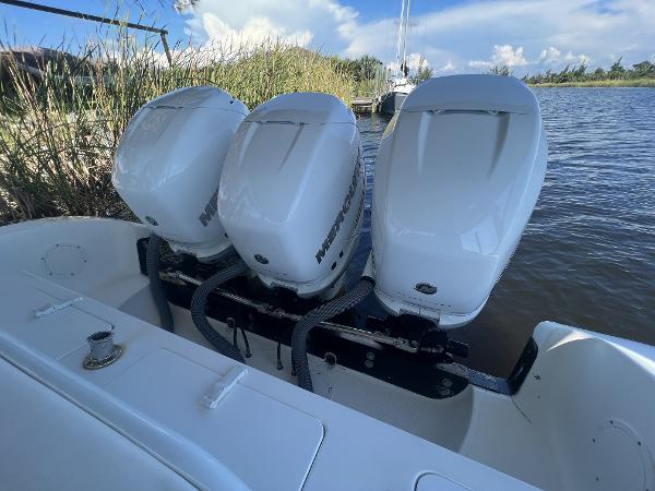 Slide: The Image of 2008 Fountain 34 CC boat with triple outboard engines on a calm waterway. - 9
