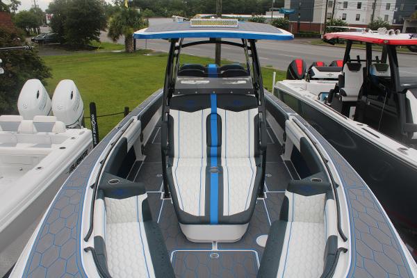 Slide: The Image of 2024 Fountain 34 SC boat with blue and white seating, docked outdoors. - 10