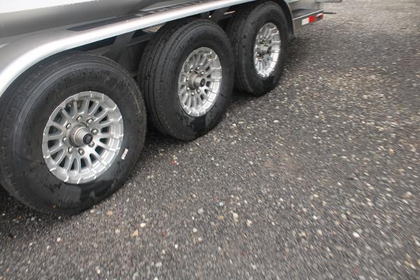 Slide: The Image of 2024 Fountain 34 SC trailer with triple axle wheels on gravel. - 13