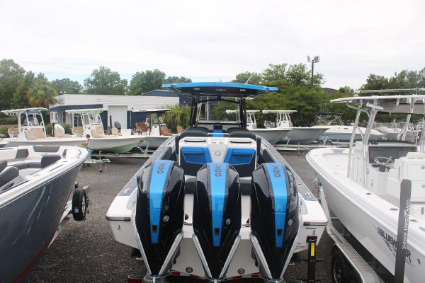 Slide: The Image of 2024 Fountain 34 SC boat with triple outboard engines in a marina. - 15