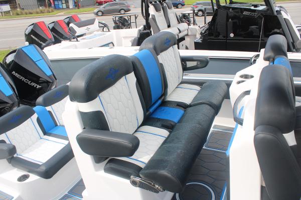 Slide: The Image of 2024 Fountain 34 SC boat interior with blue and white seating, Mercury engines in the background. - 29