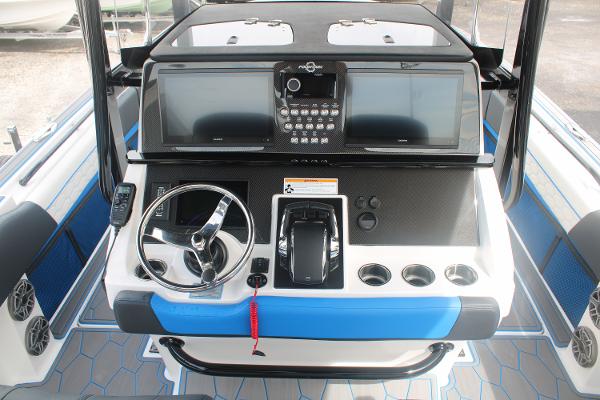 Slide: The Image of 2024 Fountain 34 SC boat dashboard with steering wheel, dual screens, and control panel. - 34