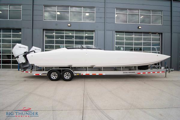 Slide: The Image of 2023 Fountain 34 Thunder Cat boat on a trailer outside a modern building. - 1