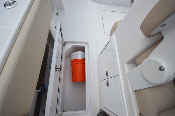 Slide: The Image of 2017 Fountain 38 Center Console storage compartment with orange bucket. - 24