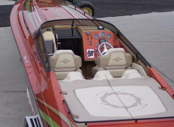 Slide: The Image of 2007 Fountain 38 Lightning speedboat with red and green accents, beige interior, and advanced dashboard. - 6