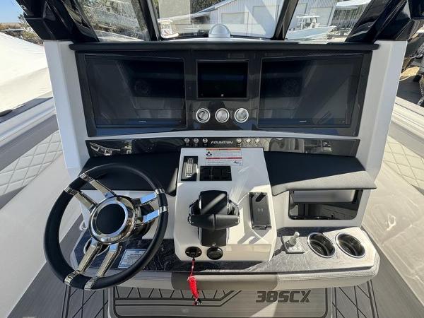 Slide: The Image of 2024 Fountain 38 SCX boat dashboard with steering wheel and control panel. - 9